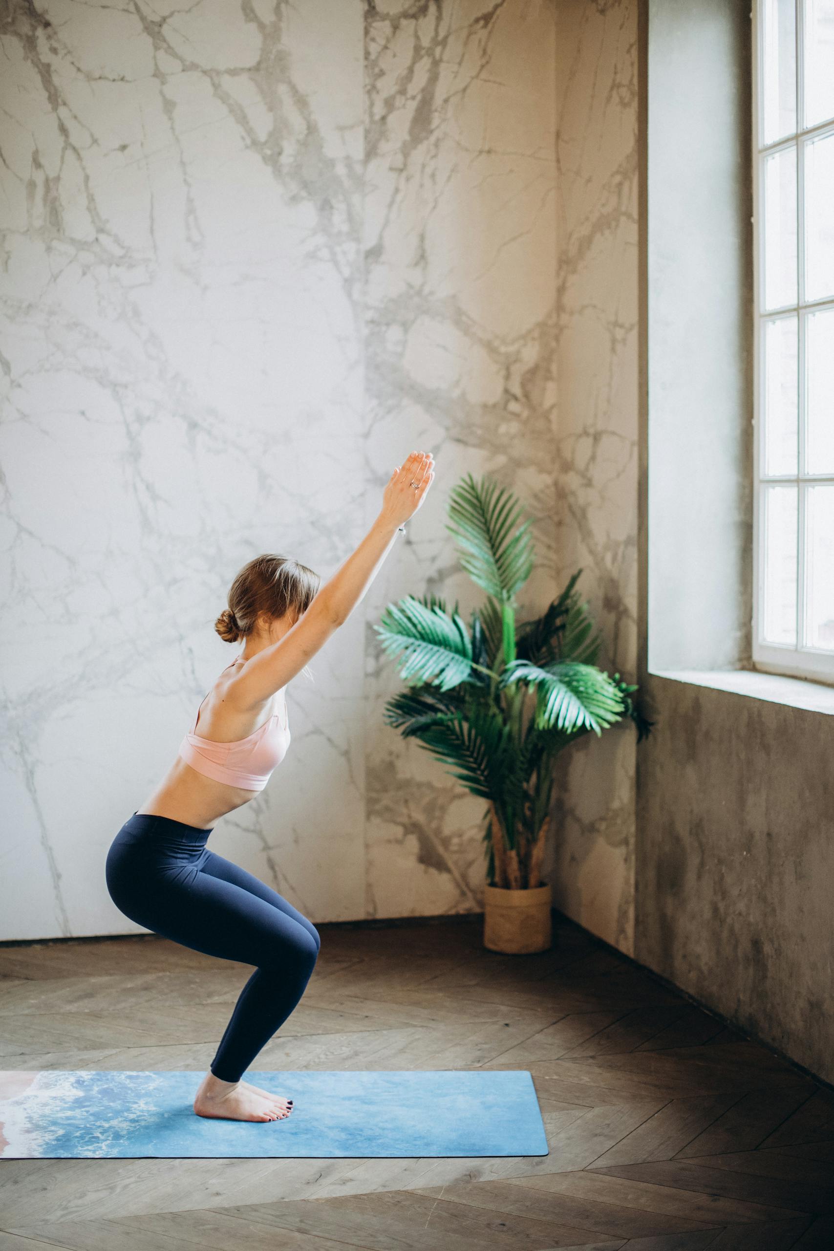 Mujer haciendo postura de yoga esenciaslow